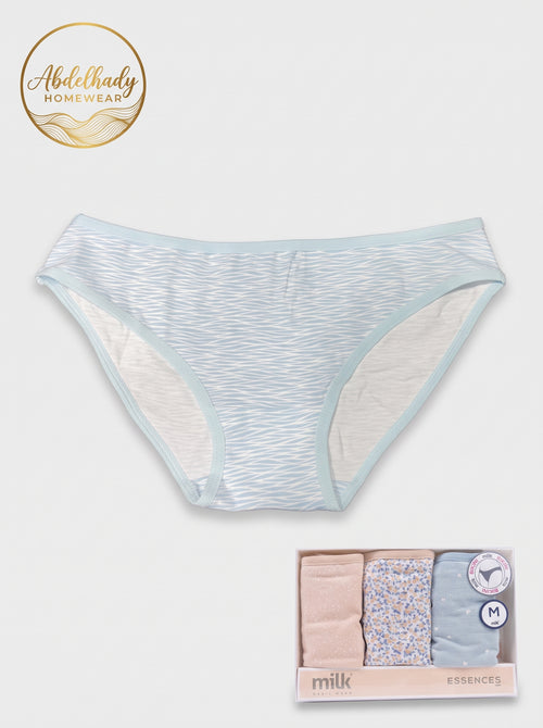 Product image featuring a women's bikini-cut cotton panty displayed flat against a plain light gray background. The underwear has a subtle light blue and white abstract wavy line pattern with solid light blue elastic trim along the waist and leg openings. In the top left corner is the circular gold Abdelhady Homewear brand logo. In the bottom right corner sits the product box labeled "milk BASIC WEAR - ESSENCES", containing three neatly folded panties in soft blush pink, floral print, and light blue, marked