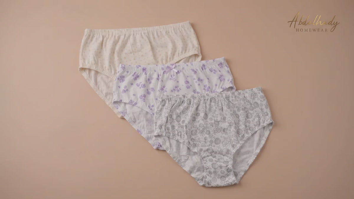 Three pairs of Abdelhady Homewear high-waisted cotton briefs with delicate floral and star patterns, laid flat on a peach background.