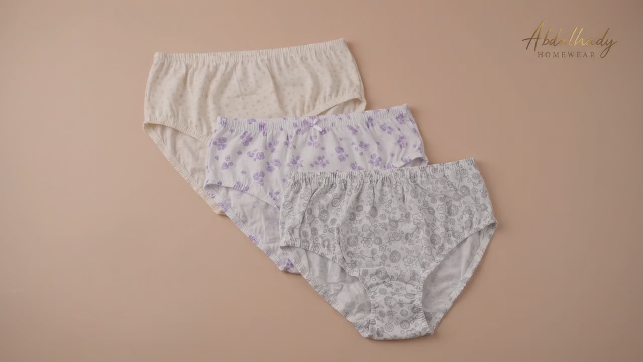 Three pairs of Abdelhady Homewear high-waisted cotton briefs with delicate floral and star patterns, laid flat on a peach background.